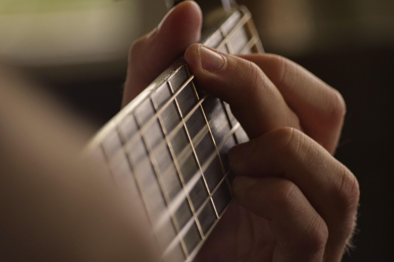 Close-up of a hand fretting a two-chord shape on a guitar